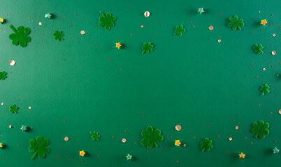 Fototapeta na wymiar Happy St. Patricks Day decoration concept. Flat lay, top view of clover leaves on green background with space for text.
