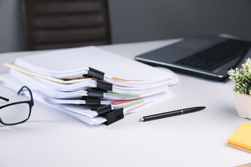 Stack of business paper file with laptop computer