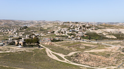 Fototapeta na wymiar View from the walls of the ruins of the palace of King Herod - Herodion of the nearby Jewish and Arab settlements in the Judean Desert, in Israel