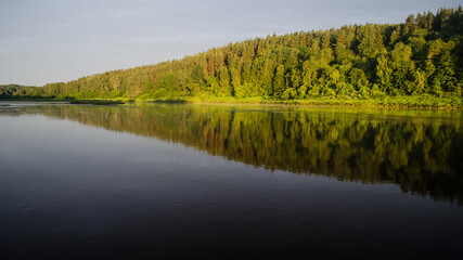 Beautiful sunny morning by the river Daugava. On the other bank of the river you can see the sunlit forest. Kraslava, Latvia