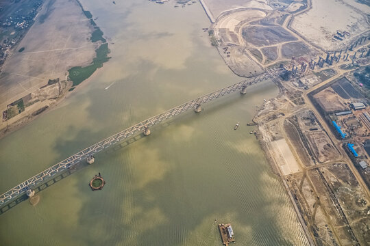 Aerial view of a building site while assembling the Padma bridge, the longest rail and highway bridge in Bangladesh crossing the Padma river, Zajira, Dhaka, Bangladesh.