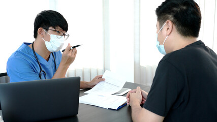 Asian man doctor wear protection face mask during coronavirus and flu outbreak is taking care examining sick patient in hospital