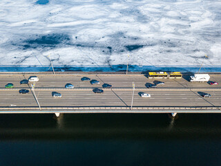 North bridge over the Dnieper river in Kiev. Aerial drone view. Sunny spring day. Crack ice melts on the river.