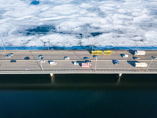 North bridge over the Dnieper river in Kiev. Aerial drone view. Sunny spring day. Crack ice melts on the river.