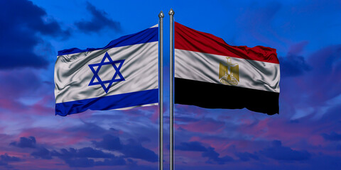 Israel and Egypt flag waving in the wind against white cloudy blue sky together. Diplomacy concept, international relations.