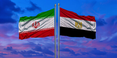 Iran and Egypt flag waving in the wind against white cloudy blue sky together. Diplomacy concept, international relations.