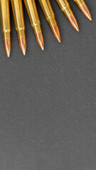 Bullets on gray paper background. Cartridges 7.62 caliber for Kalashnikov assault rifle. Template,...