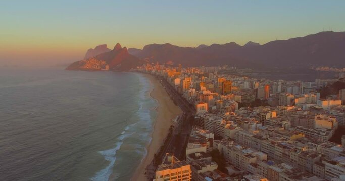 Rio de Janeiro sunrise over buildings on ipanema beach with mountains in the background