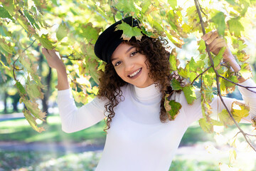 Portrait of a curly teenage girl enjoying a beautiful day in the park