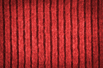 Texture of red woolen fabric. Texture of a red sweater with a pattern. Red background