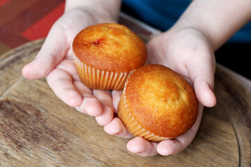 Two muffins in children's hands, sweet food