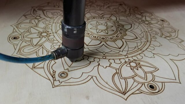 modern industrial equipment. Laser cutting on wood. The laser beam passes through the plywood, cuts out a drawing or pattern. processing wooden products. Modern technologies in woodworking