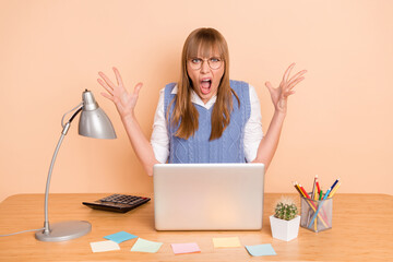 Photo portrait of woman shouting irritated deadlines angry mad working on laptop isolated on pastel beige color background