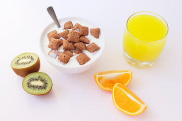 Healthy lifestyle. Healthy breakfast with a glass of juice and fruit. Fruit and sweet pads for breakfast. Orange and kiwi. Healthy breakfast on a white background.