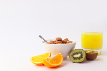 Healthy lifestyle. Healthy breakfast with a glass of juice and fruit. Fruit and sweet pads for breakfast. Orange and kiwi. Healthy breakfast on a white background.