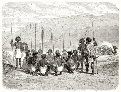 Afar people gathered in a circle with spears and shields outdoor on a desertic land in Ethiopia. Ancient grey tone etching style art by Hadamart, Magasin Pittoresque, 1838