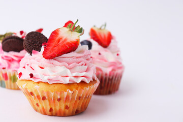 Sweet cake on a white background. Strawberry cake. Three cakes on a white plate. Background with cakes for a postcard.