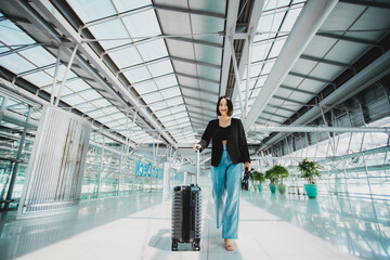 Young Asian woman dragging luggage in the airport