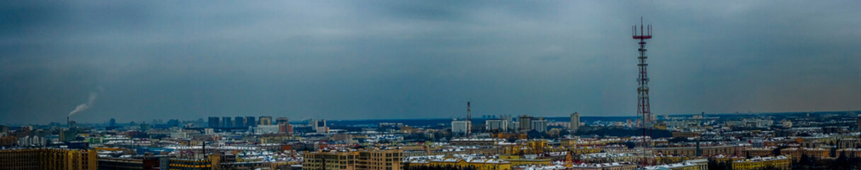 Panoramic cityscape of Minsk downtown in twilight. Roofs of houses and television tower on dramatic sky background.