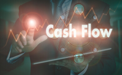 A businessman operating a computer display with a Cash Flow business word concept on it.