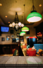 Empty wooden table top with lights bokeh on blur restaurant background.