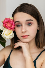 Portrait of beautiful dark-haired woman with flowers. Fashion photo, Pretty little girl with pink rose