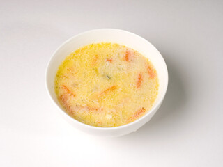 Cheese soup in a white round bowl. Studio photo on white background