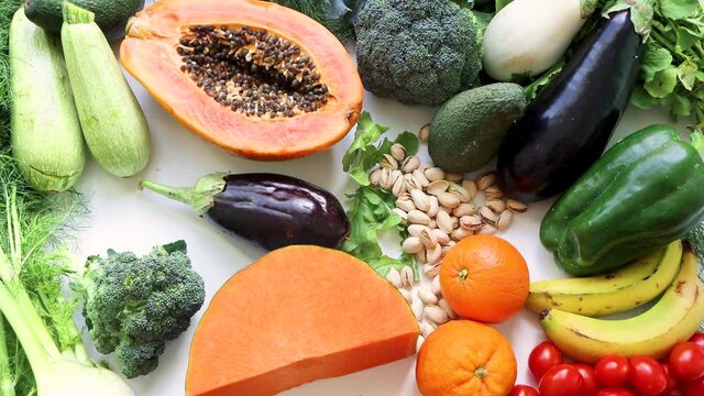 Male hand takes red pepper on healthy food clean eating selection: fruit, vegetable, avocado, papaya, pumpukin superfood, leaf vegetable