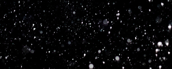 Falling snowflakes in the dark night.