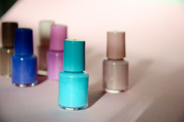 Group of pastel colored nail polishes isolated on pink bacground