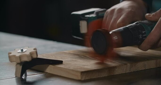 Carpenter uses electric screwdriver with abrasive nylon brush, brushing wood in slow motion, woodworking at workshop, 4k 60p Prores 422 HQ 10 bit
