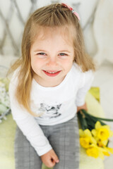 Close up of little girl with yellow flowers