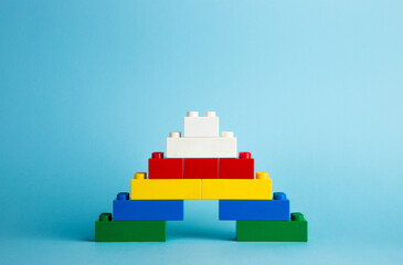 Color plastic building blocks on red background