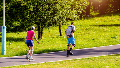 Obraz premium A man and a woman ride on roller skates 