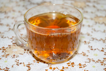 close-up - black tea in a transparent glass cup on the table