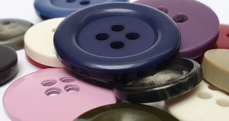 Botón oscuro sobre montón de botones costura