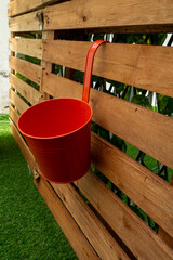 Red Pot Hanging on a Wooden Pallet Background