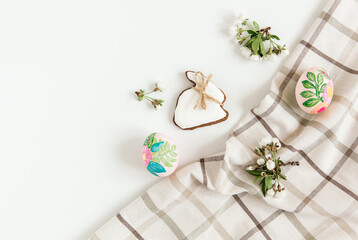 Easter composition from painted eggs, flowers,easter gingerbread and tablecloth. White background.