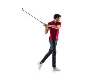 Golf player in a red shirt taking a swing isolated on white studio background with copyspace. Professional player practicing confident, emotions and facial expression. Sport, motion, action concept.