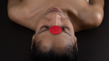 Brunette woman lying on a therapeutic stretcher with biomagnetism therapy magnets placed on her forehead to treat her health with holistic therapies and alternative medicine