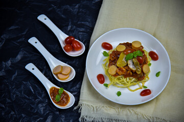 Delicious classic Italian spaghetti with tomato sauce, Parmesan cheese and mint leaves on a plate. There is a writing area.