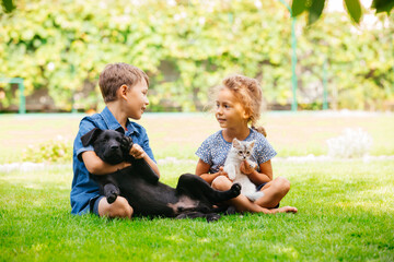 Naklejka na ściany i meble Cheerful brother and sister happily chatting in park