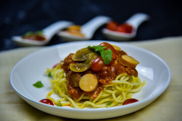 Delicious classic Italian spaghetti with tomato sauce, Parmesan cheese and mint leaves on a plate. There is a writing area.