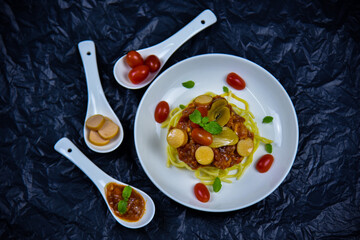 Delicious classic Italian spaghetti with tomato sauce, Parmesan cheese and mint leaves on a plate. There is a writing area.