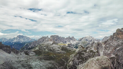 Fototapeta na wymiar A panoramic view on Italian Dolomites. There are many high and sharp peak in front, with many landslides. Dangerous climbing. Barely any plants growing in the area. Raw and unspoiled landscape.