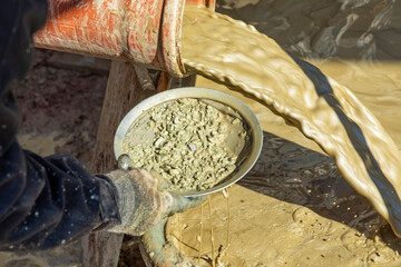 water mixed with loam from an artificial fountain drilling machine and stones checked with a...
