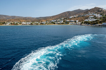 Water trail behind the ferry. Bay of Ios island in southern Cyclades. Greece