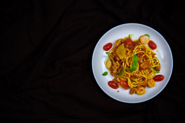 Delicious classic Italian spaghetti with tomato sauce, Parmesan cheese and mint leaves on a plate. There is a writing area.