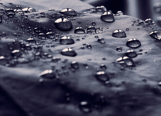 Water drops on waterproof membrane fabric. Detail view of waterproof cloth.