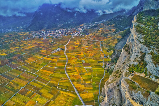Aerial view of a waving road in countryside going to Ardon township with mountain range in background, Ardon, Switzerland.